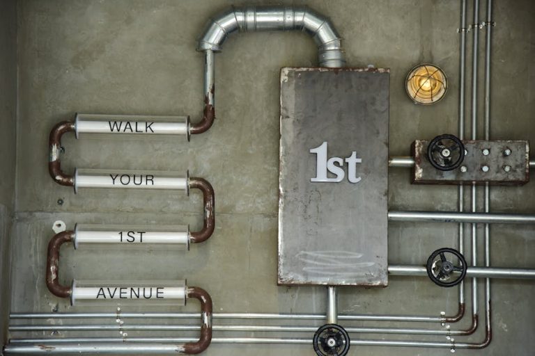 Industrial wall art featuring pipes and text on a concrete wall with a vintage style.