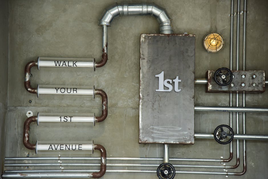Industrial wall art featuring pipes and text on a concrete wall with a vintage style.