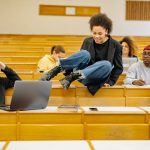 Diverse students interact and study in a university lecture hall.