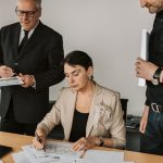 The Antifragile Executive: Why Homogeneity is Your Greatest Strategic Liability Business professionals collaborating on financial documents in an office setting.