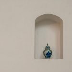 The Architecture of Advantage: Niche Construction for Leaders Elegant blue porcelain vase displayed on a minimalist white wall shelf with ample copy space.