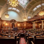 A beautifully designed chamber room with ornate woodwork and chandeliers in the UK.