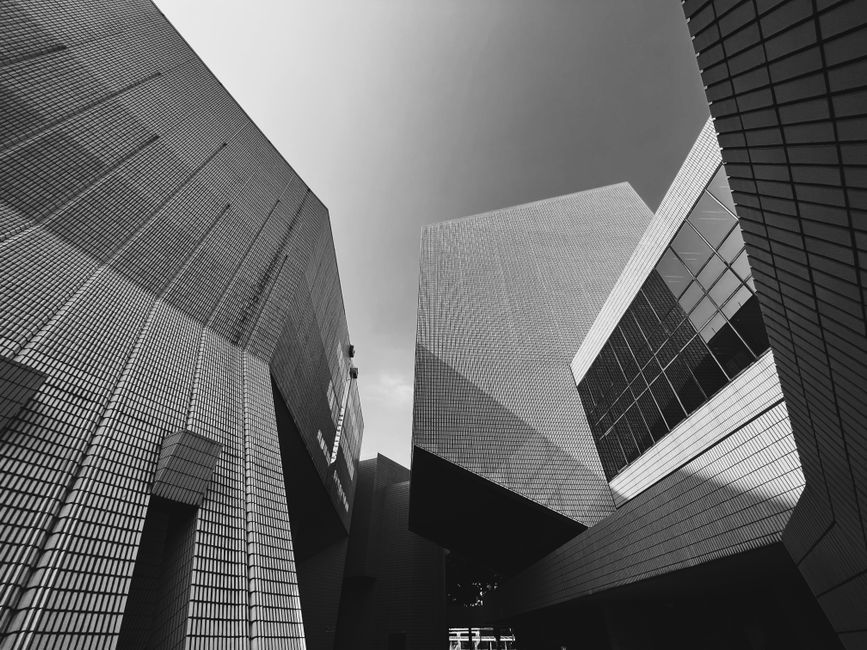 Black and white photo of a modern architectural building with dynamic geometric shapes.