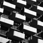 The Architecture of High-Performance Habitats: Lessons for CEOs Black and white photo of a modern building facade with geometric balconies.