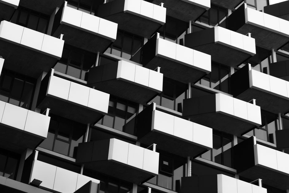 Black and white photo of a modern building facade with geometric balconies.