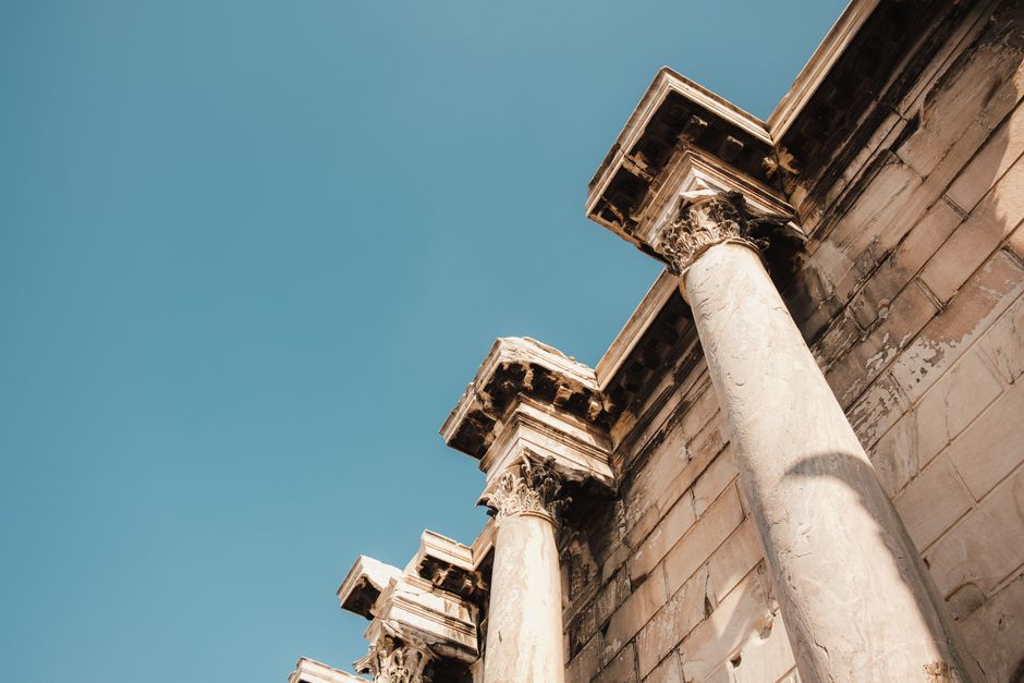 Majestic ancient columns stand tall under a clear blue sky, showcasing historic architectural beauty.