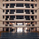 Wide view of a modern university building in Dehradun, India, highlighting architectural design and stairs.