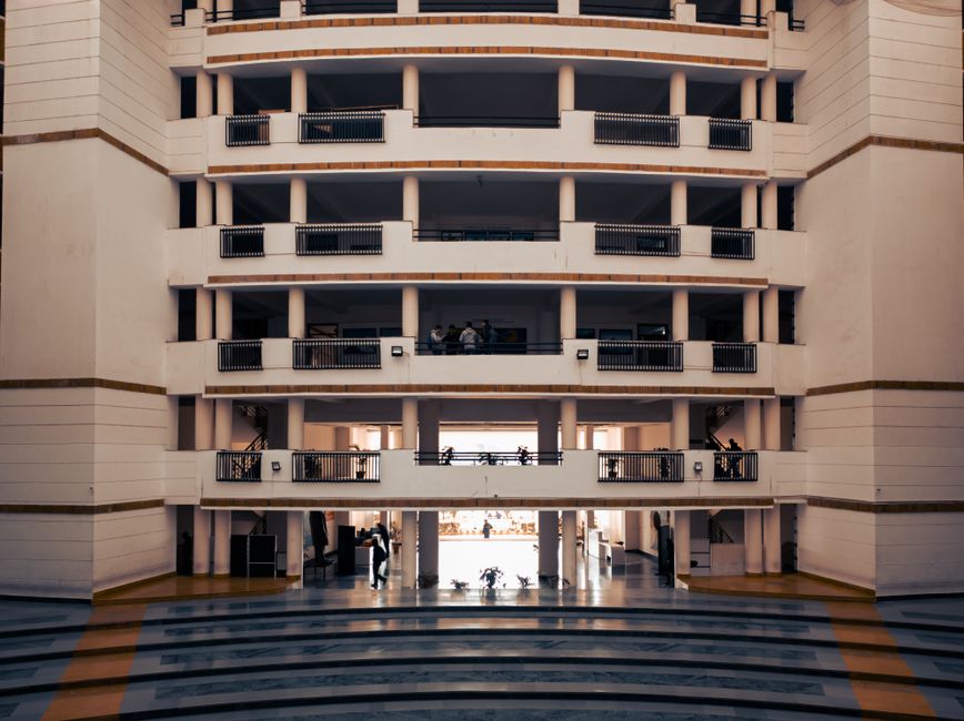 Wide view of a modern university building in Dehradun, India, highlighting architectural design and stairs.