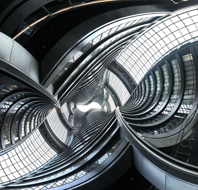 Dynamic interior view of modern architectural structure with twisting metal and glass design.