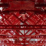 Detailed view of a red steel framework showing geometric patterns and industrial design.