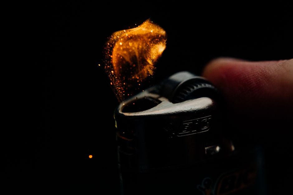 A macro shot capturing the ignition spark of a lighter in a dim setting.