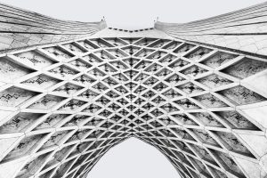 Black and white abstract view of Azadi Tower's intricate geometric lattice in Tehran.
