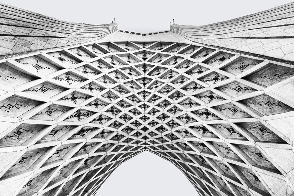 Black and white abstract view of Azadi Tower's intricate geometric lattice in Tehran.