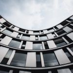The Architecture of Predictive Certainty: Strategic Forecasting Stunning upward view of a modern curved building in Hamburg. A blend of glass and steel.
