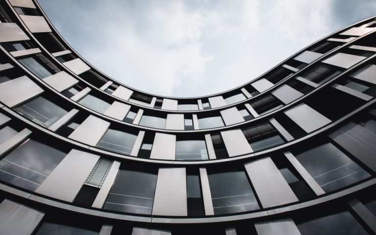 Stunning upward view of a modern curved building in Hamburg. A blend of glass and steel.