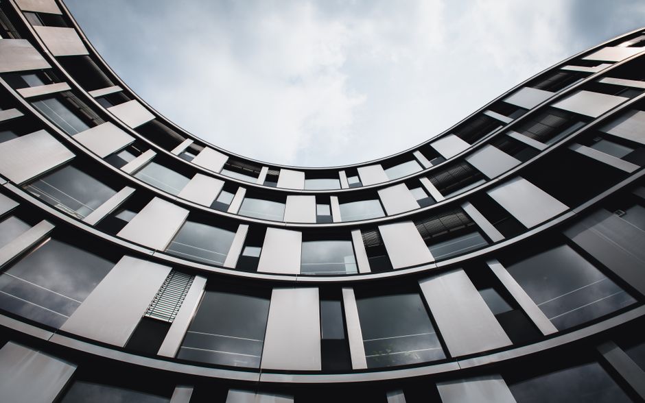 Stunning upward view of a modern curved building in Hamburg. A blend of glass and steel.