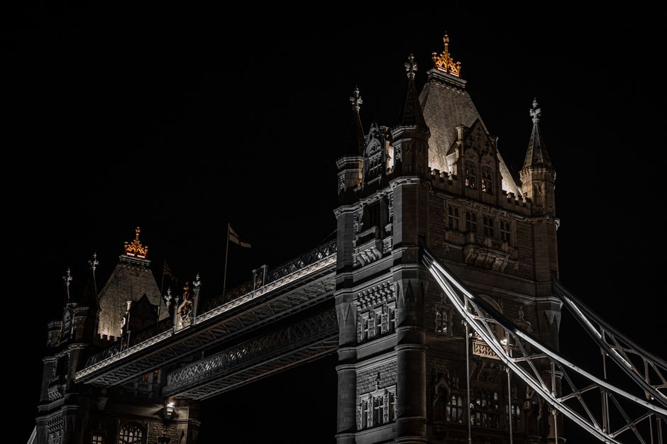 Night view of London’s iconic Tower Bridge with dramatic lighting.