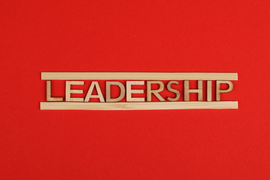 Wooden letters spelling leadership on a vibrant red background, conveying bold concepts.