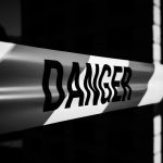 Close-up of a danger tape in black and white, emphasizing caution and warning.