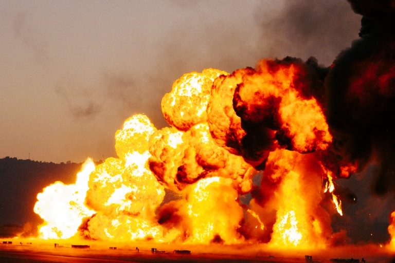 Powerful explosion with massive flames and smoke during daytime.