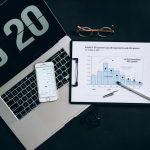 The Data Integrity Crisis in Global Climate Monitoring Systems Top view of financial analysis tools on a desk including a laptop, smartphone, and graphs.