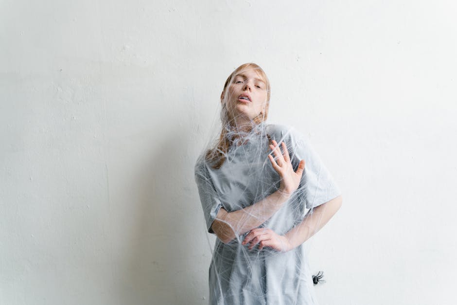 A woman trapped in spider webs, capturing a sense of entrapment and anxiety.