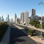 The Economic Mirage of Post-Scarcity: Strategic Leadership Panoramic view of Kuwait City skyline featuring modern skyscrapers and urban landscape under a clear sky.
