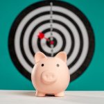 The Economics of Scarcity: Strategic Water Desalination Guide Piggy bank with bullseye dart board symbolizing financial goals and savings.