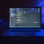 The End of Infinite Compute: Why 'Efficiency Debt' Is the New Tech Bankruptcy Close-up of a laptop screen displaying code, set against a dark backdrop with blue lighting for a tech-focused ambiance.