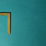 Minimalist image of a golden numeral seven on a teal background, ideal for decorative use.