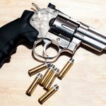 The Fallacy of the 'Silver Bullet': Why Incrementalism Beats Grandiose Legislation Silver revolver and bullets on a wooden surface illustrating security themes.