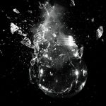 A dramatic image of a light bulb shattering into pieces against a dark background.