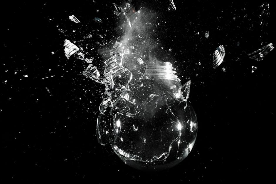 A dramatic image of a light bulb shattering into pieces against a dark background.
