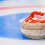 The Friction Advantage: Why 'Slow' Innovation Outperforms 'Fast' Disruption Round curling stone with red handle placed on ice surface on ice rink in daytime