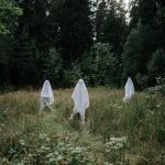 The Ghost Asset Paradox: Why Your Office Strategy Is Draining Your Bottom Line Three people dressed as ghosts in a forest setting evoke Halloween mystery and spirit.