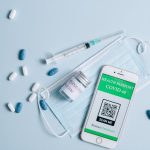 The Green Coding Mandate: Why Software Efficiency is Your Best Hedge Against Climate Volatility Flat lay of COVID-19 health passport, mask, vaccine vial, syringe, and pills on blue background.
