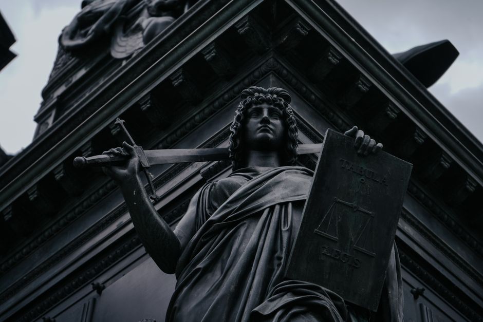 Striking statue of Lady Justice holding sword and scales in Dresden, Germany.