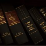 The Jurisprudential Vacuum of Exobiology: Legal Risks for Firms Stack of legal and literature books in a library showcasing various volumes.