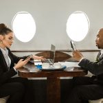 The Nomad Executive: Why Your 'Home Base' is Killing Your Decision Velocity Two business professionals working on digital devices inside a private jet.