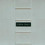 The Permissioned Trap: Why Decentralization is the Wrong Metric for Enterprise Success A minimalistic image featuring a 'Crew Only' sign on a ladder against a white wall.