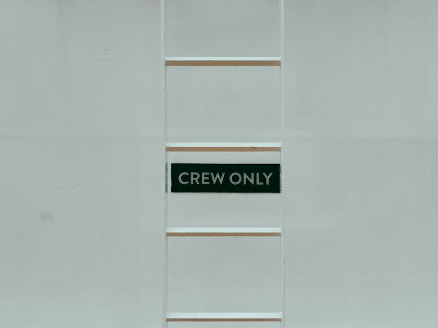 A minimalistic image featuring a 'Crew Only' sign on a ladder against a white wall.