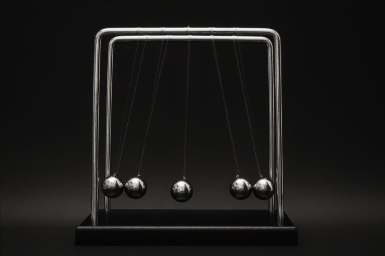 Newton's cradle for physics principles and motion study on a dark background.