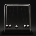 Newton's cradle for physics principles and motion study on a dark background.