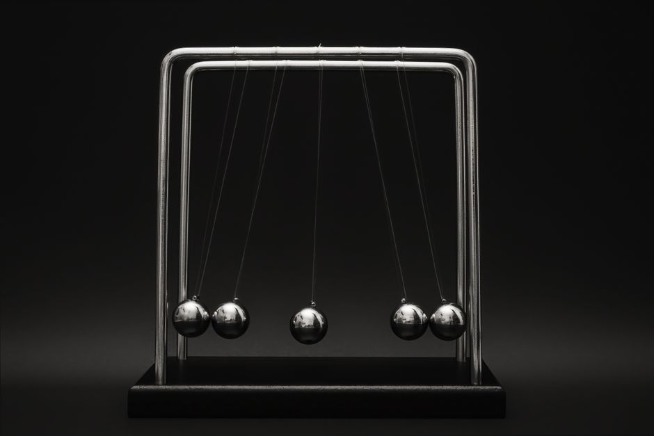 Newton's cradle for physics principles and motion study on a dark background.