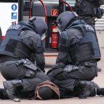 German police in full gear detain a suspect in an urban area in Hamburg.