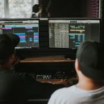 The Post-Human Transition: Mastering Agility in Modern Strategy Two men working in a music studio with dual monitors displaying audio editing software.