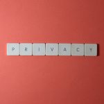 The Privacy Paradox: Why Bio-Apparel Demands a New Leadership Ethic Close-up of letter tiles spelling PRIVACY on a red background, symbolizing data protection.
