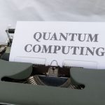 A vintage typewriter with a paper displaying the term Quantum Computing.