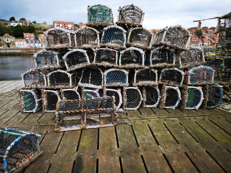 Pile of fishing cages on a pier in a coastal town, ready for use.