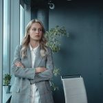 The Silent CEO: Why Unshared Insights Are Your Competitive Advantage A professional businesswoman stands confidently in a modern office, exuding leadership and determination.